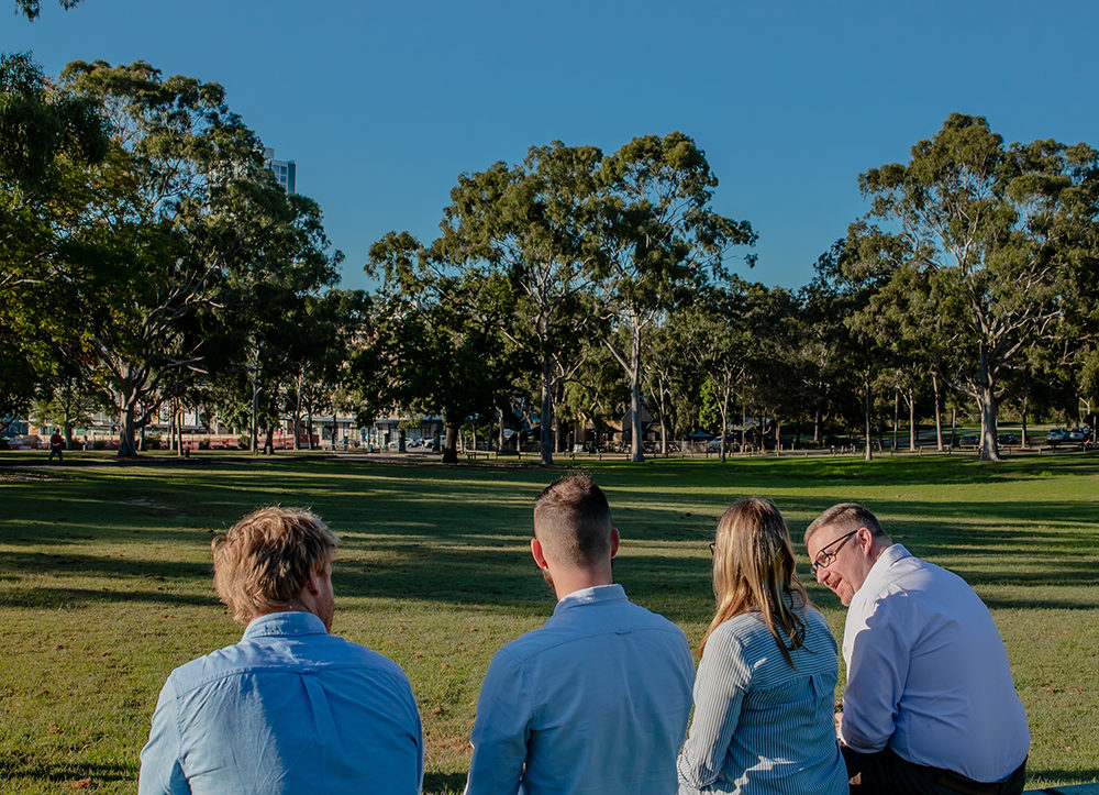 team photo of civil engineers outside under clear blue sky laughing and smiling craig stoddart rachael oertel james brand michael bell
