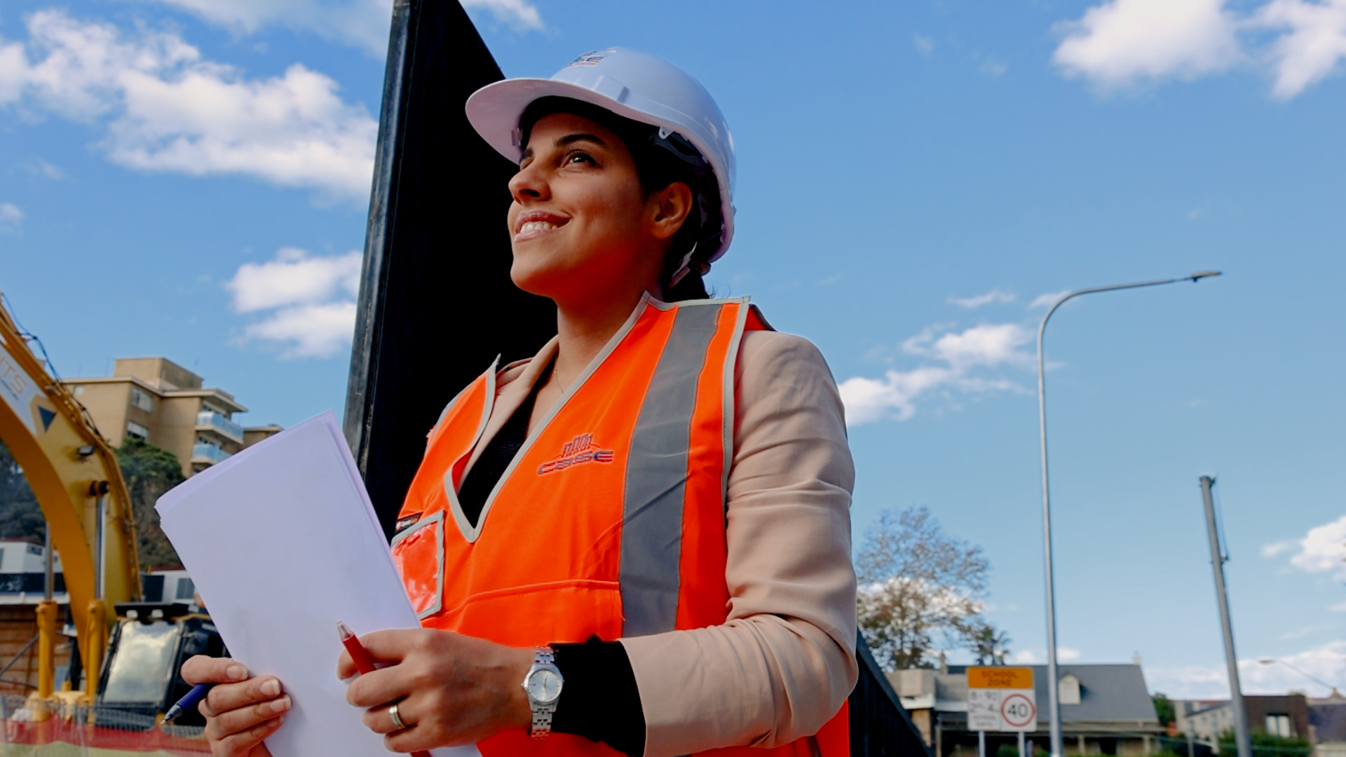 a portrait of female civil engineer elnaz ebrahimi on construction site wearing protective hard hat and hi vis vest